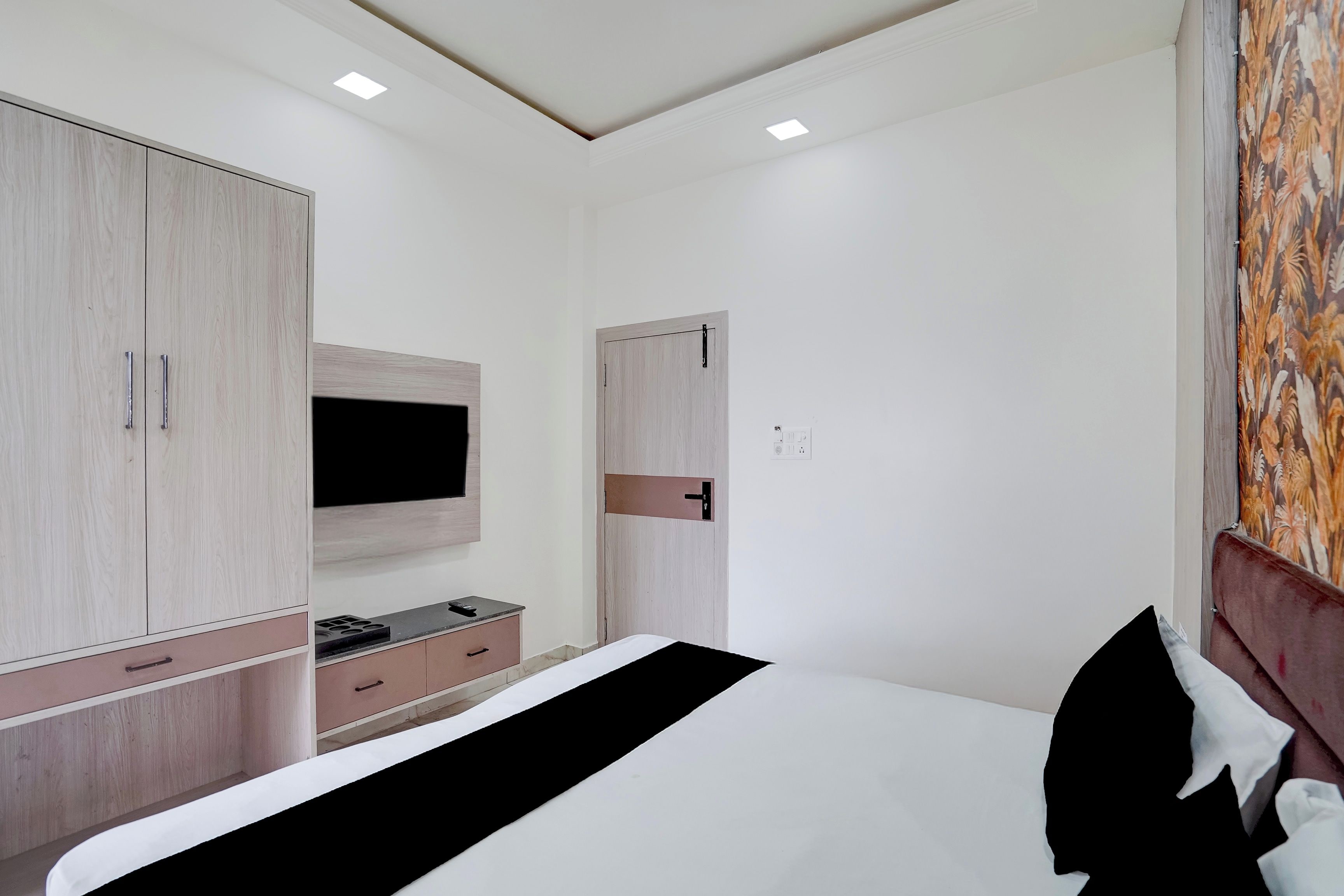 Una camera da letto con un letto, un armadio e una televisione a parete.