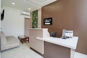 A reception desk with a sign, a sofa, a small table, and a printer. - Collection O Rudrapur Bus Terminal (Rudrapur)