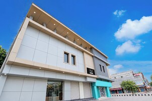 Un edificio moderno con techo plano, ventanas grandes y escaparate con un letrero.