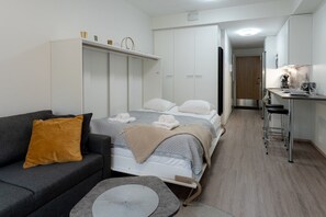 A compact room with a bed, a sofa, a desk, and a kitchenette. - Levi South Studio 1 and 2, Sauna By Lapland Host (Kittilä)