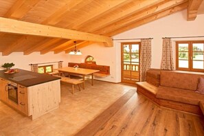 A wooden interior with a kitchen, dining area, and seating space. - Holiday apartment with 2 bedrooms (Bernau)