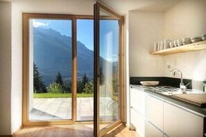 Cozinha com vista para as montanhas através de uma porta de correr.