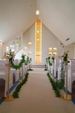 A church interior with pews, a central aisle, and a decorative altar. - Hotel Tenchikaku (Hitachi)