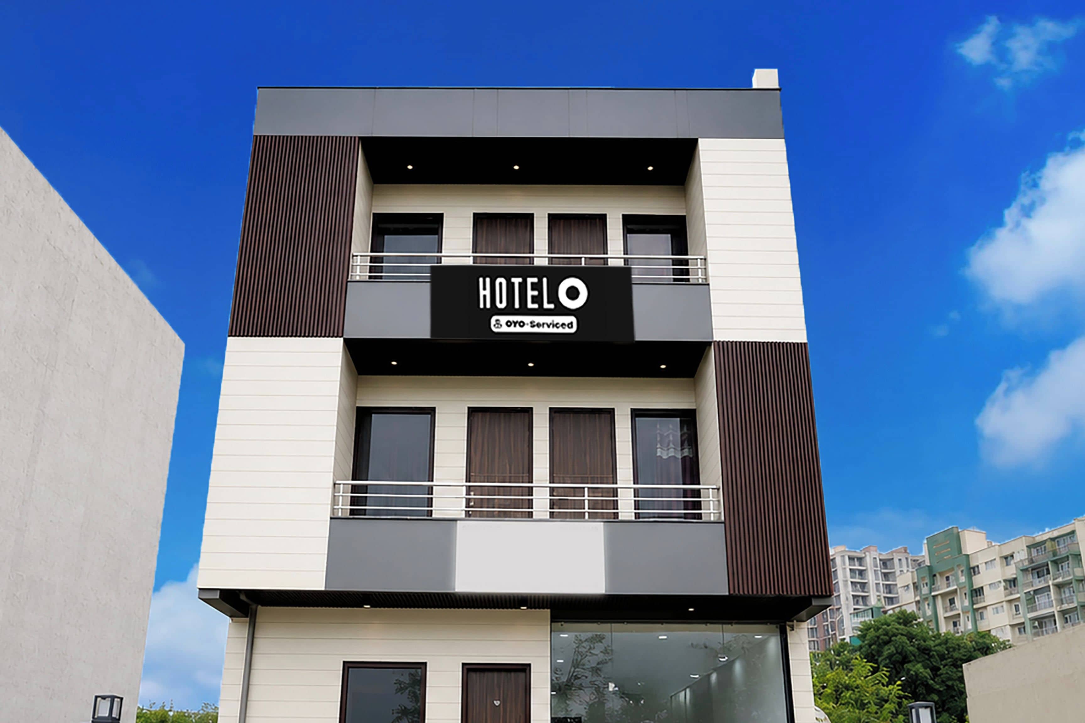 Un moderno edificio de hotel con un letrero que dice 'HOTEL' y 'OYO-Serviced'.