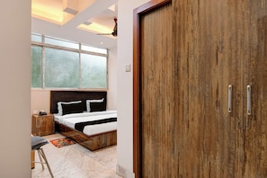Un dormitorio con una cama, un armario de madera, una ventana con persianas y un ventilador de techo.