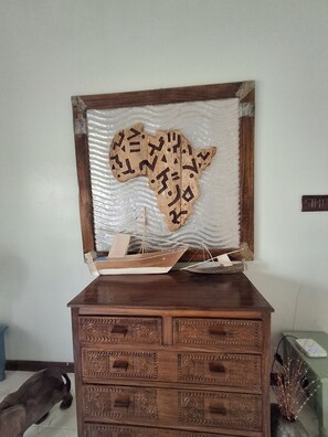 Une commode en bois ornée de motifs sculptés et d’une carte décorative gravée à l’arrière.