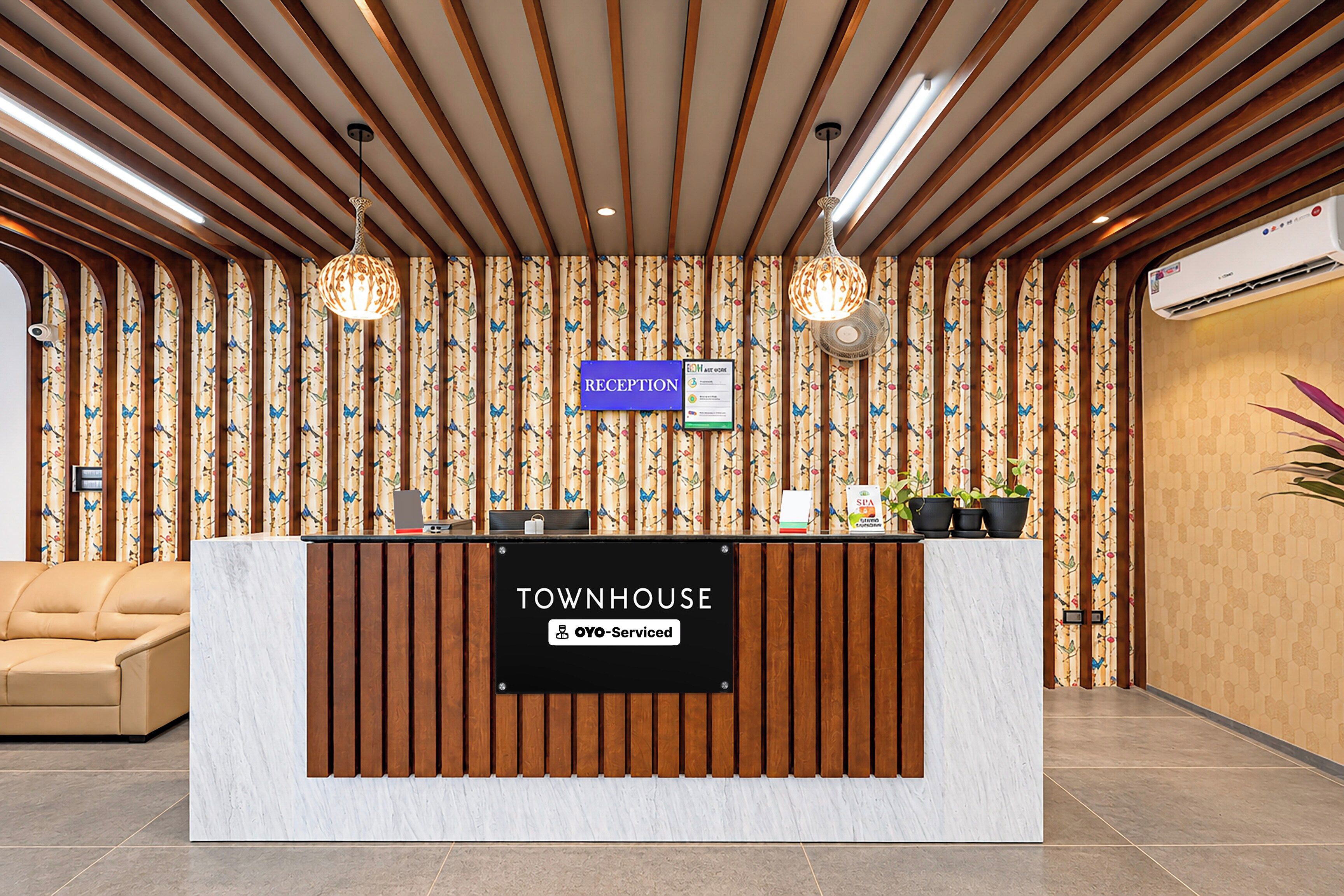 A reception desk with a sign reading 'RECEPTION' and 'TOWNHOUSE OYO-Serviced'.