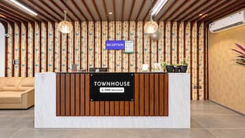 A reception desk with a sign reading 'RECEPTION' and 'TOWNHOUSE OYO-Serviced'.