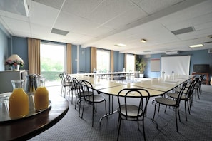 A conference room with a long table, chairs, and a projector screen. - Balladins Villefranche de Rouergue (Villefranche-de-Rouergue)