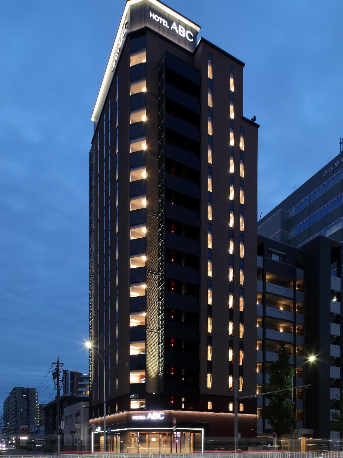 A modern hotel building with multiple floors and a prominent 'HOTEL ABC' sign.