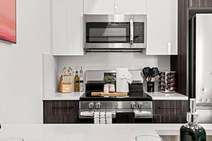 A modern kitchen with a stainless steel microwave, a gas stove, and a built-in oven.