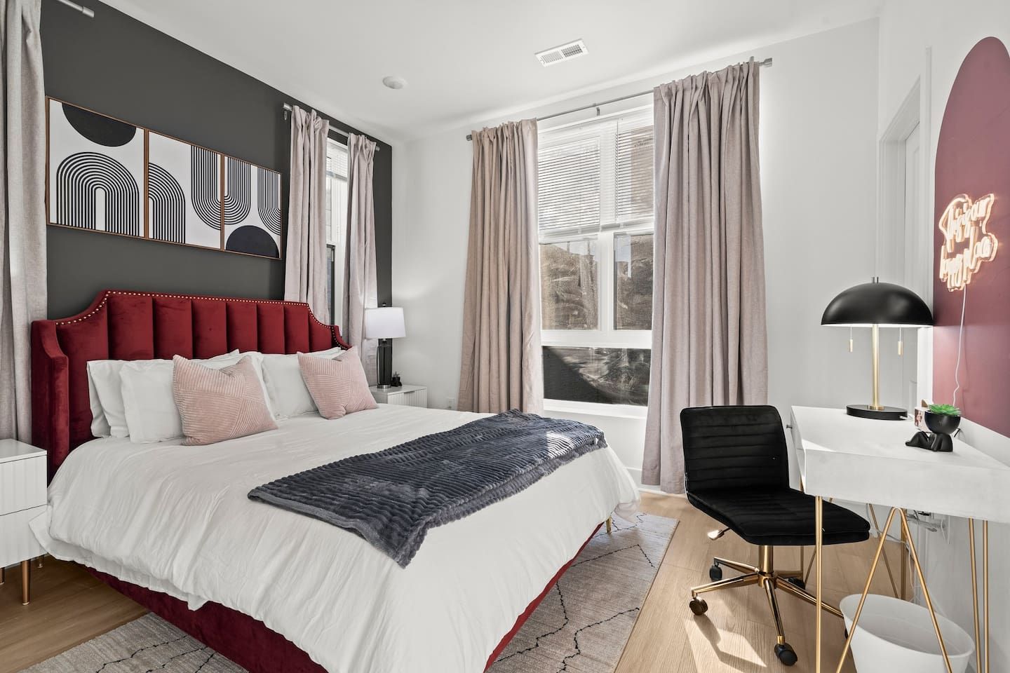 A modern bedroom with a large bed, a desk, and a chair.