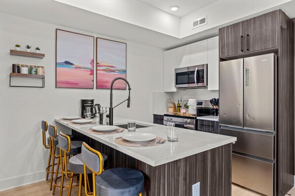 A modern kitchen with a central island, stainless steel appliances, and a minimalist design.