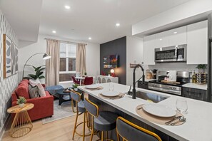 A modern apartment with a kitchen, dining area, and living room.