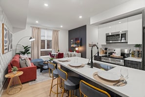 A modern apartment with a kitchen, dining area, and living room. - Bright Boutique Condo | Parking | Downtown•Univ City (Philadelphia)