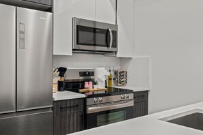 Eine moderne Küche mit Edelstahlgeräten, einer Mikrowelle und einem eingebauten Backofen.