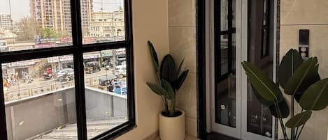 Un interior moderno con amplios ventanales, suelo de mármol y plantas en macetas.