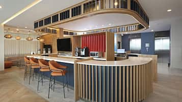 Cozinha moderna com ilha curva, banquetas e eletrodomésticos embutidos.