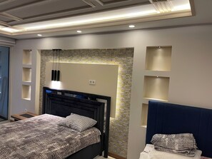 A modern bedroom with a bed, built-in shelving, and a stone accent wall. - One Bedroom Apartment Near Beykent Metrobus Station (Istanbul)