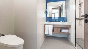Ein modernes Badezimmer mit Toilette, Waschbecken mit Spiegel und Dusche.