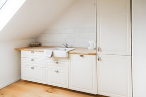 A small kitchenette with a sink, cabinets, and a countertop.
