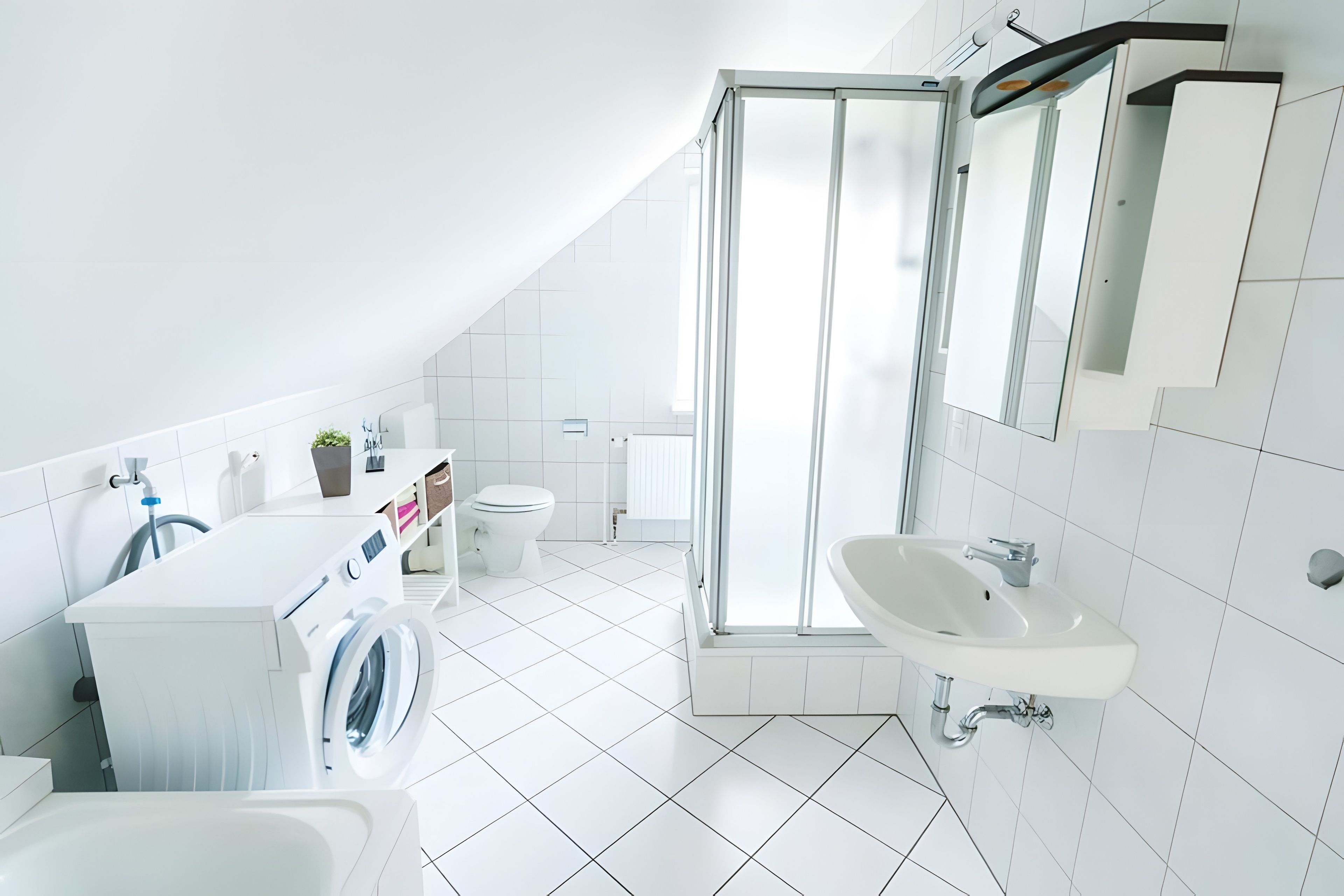 Ein modernes Badezimmer mit Waschmaschine, Toilette, Dusche und Waschbecken.