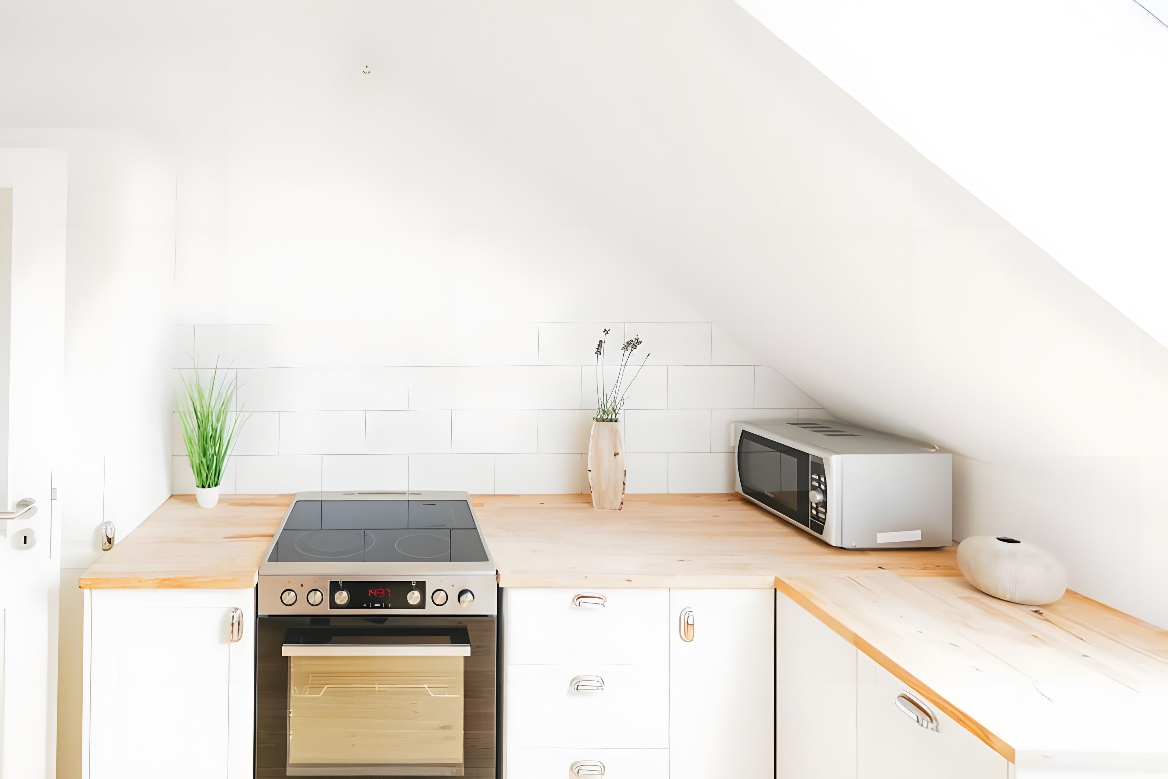 A modern kitchen with a built-in oven, a microwave, and a wooden countertop.