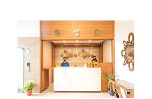 Una recepción con fondo de madera, tres relojes de pared y un adorno mural.