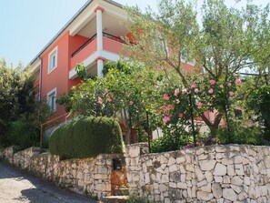 Een rood gebouw met een stenen muur en een verzorgde tuin.