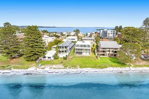 A coastal residential area with modern houses, a beach, and a clear view of the sea. - Waterfront Bliss at Soldiers Point – Step Straight Onto the Beach (Soldiers Point)