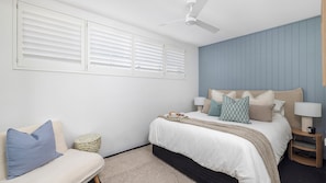 A bedroom with a bed, bedside tables, a ceiling fan, and a window with blinds. - Waterfront Bliss at Soldiers Point – Step Straight Onto the Beach (Soldiers Point)