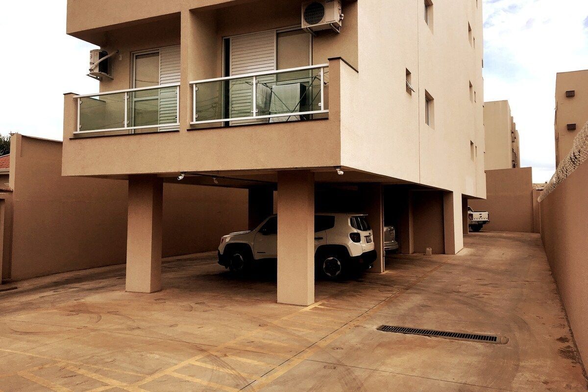 A multi-story residential building with a covered parking area underneath.