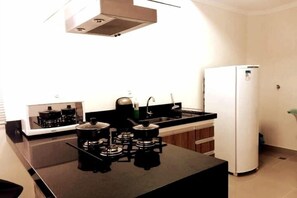 A kitchen with a stove, sink, and refrigerator. - EdifÃcio 1125 (São José do Rio Preto)