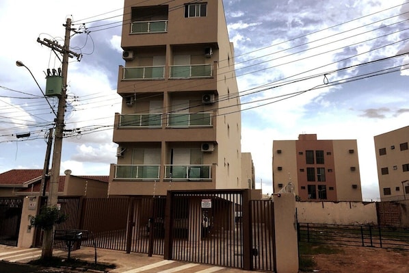 A multi-story residential building with balconies, a gated entrance, and a utility pole with multiple wires. - EdifÃcio 1125 (São José do Rio Preto)