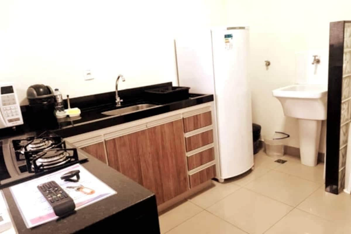 A compact kitchen with a stove, sink, and refrigerator.