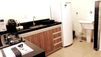 A compact kitchen with a stove, sink, and refrigerator.