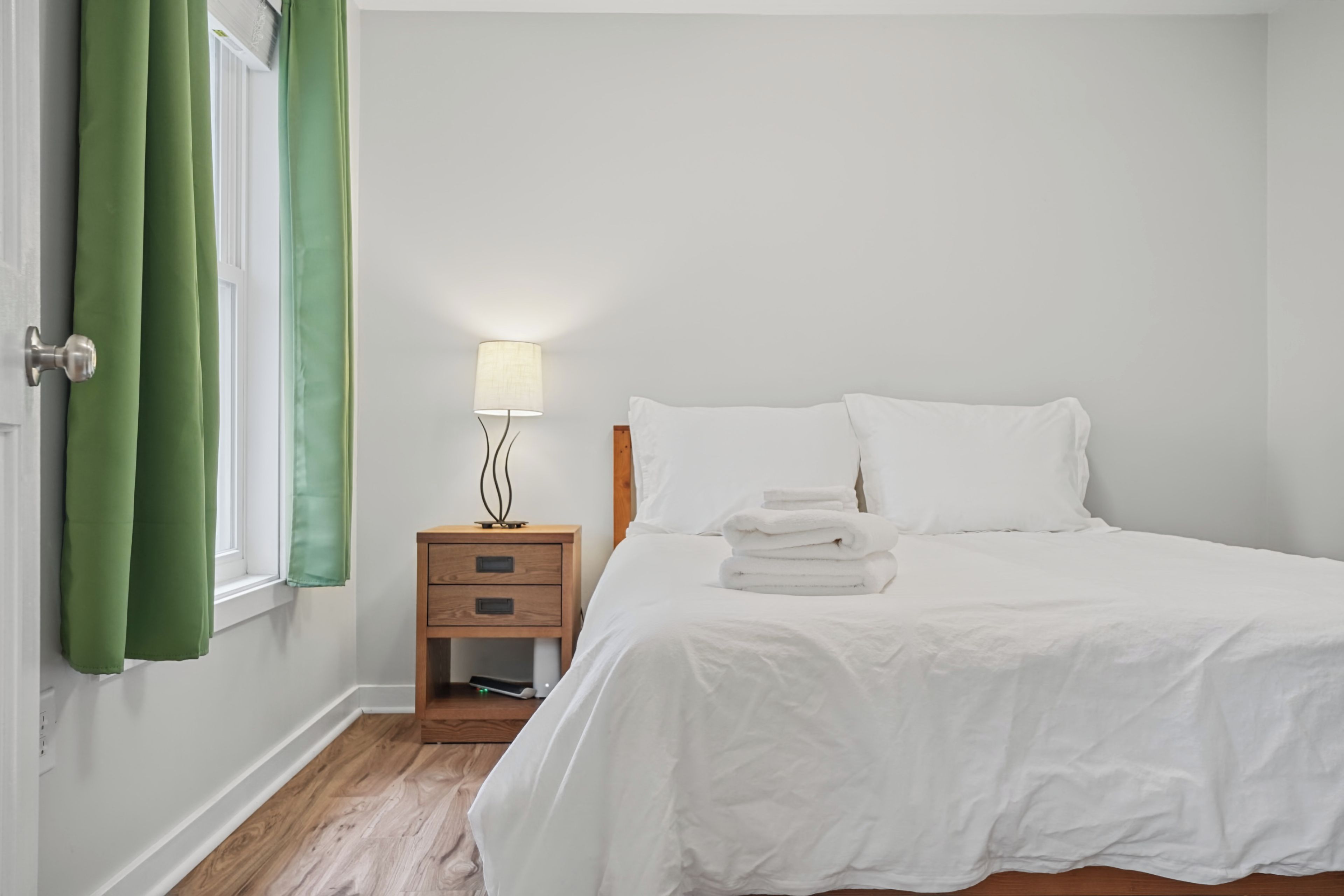 Warm, sunlit bedroom showcasing rich hardwood floors.