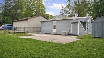 Un immobile residenziale con giardino recintato, garage e un deposito.