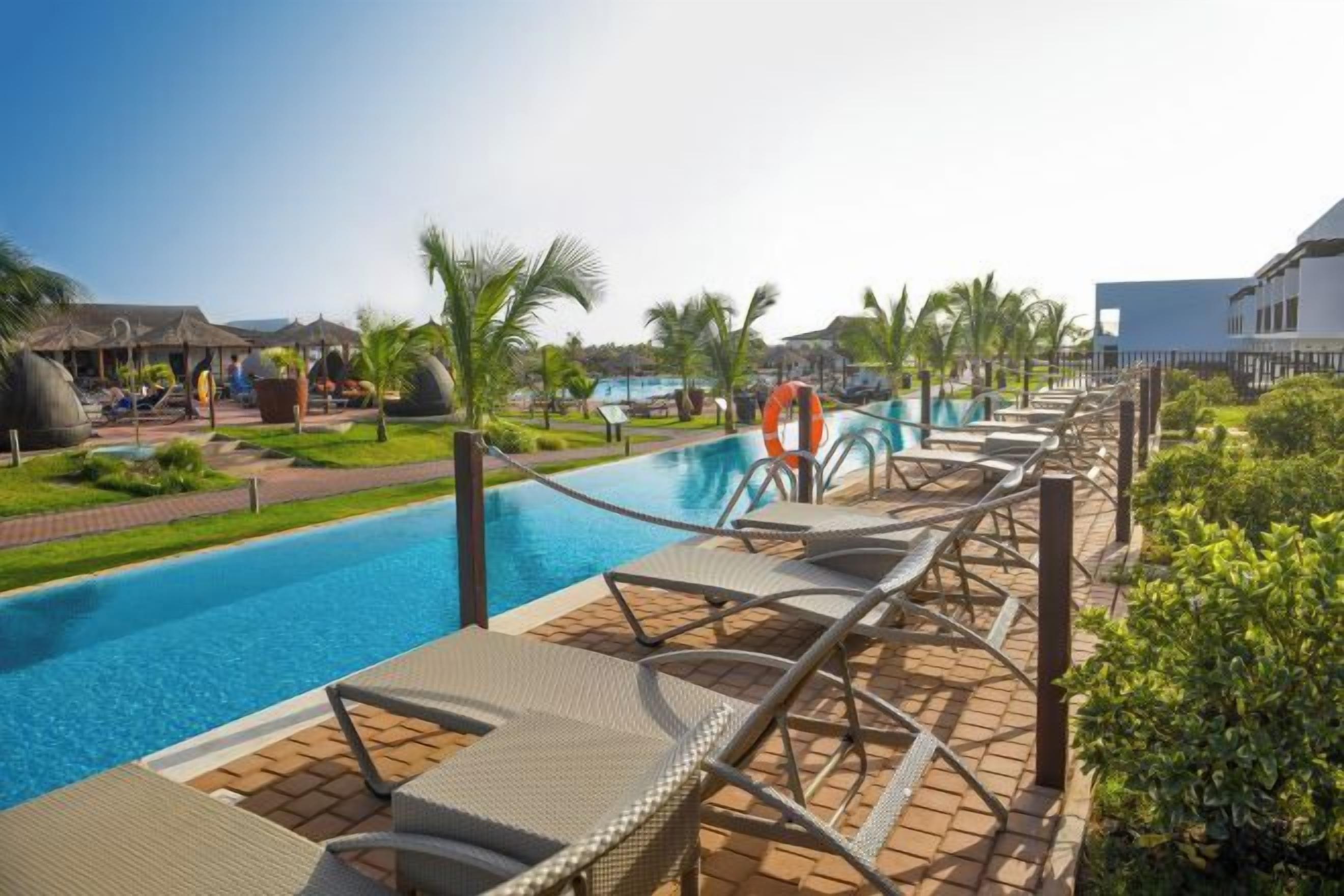 A poolside area with lounge chairs, a lifebuoy, and a clear view of the pool.