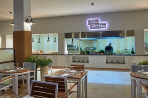 Un restaurante de diseño moderno, con una zona de cocina central, mesas y sillas.