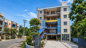 A multi-story residential building with balconies, a gated entrance, and surrounding greenery. - Hotel O Atala Main Road (Balianta)