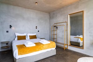 A modern hotel room with a large bed, a walk-in closet, and a large mirror. - A breathtaking view, peace, quiet, nature, and of course, great waves! (São Vicente)