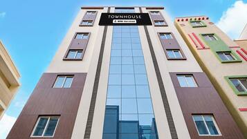 A multi-story building with a sign reading 'TOWNHOUSE' and 'OYO-Serviced'.