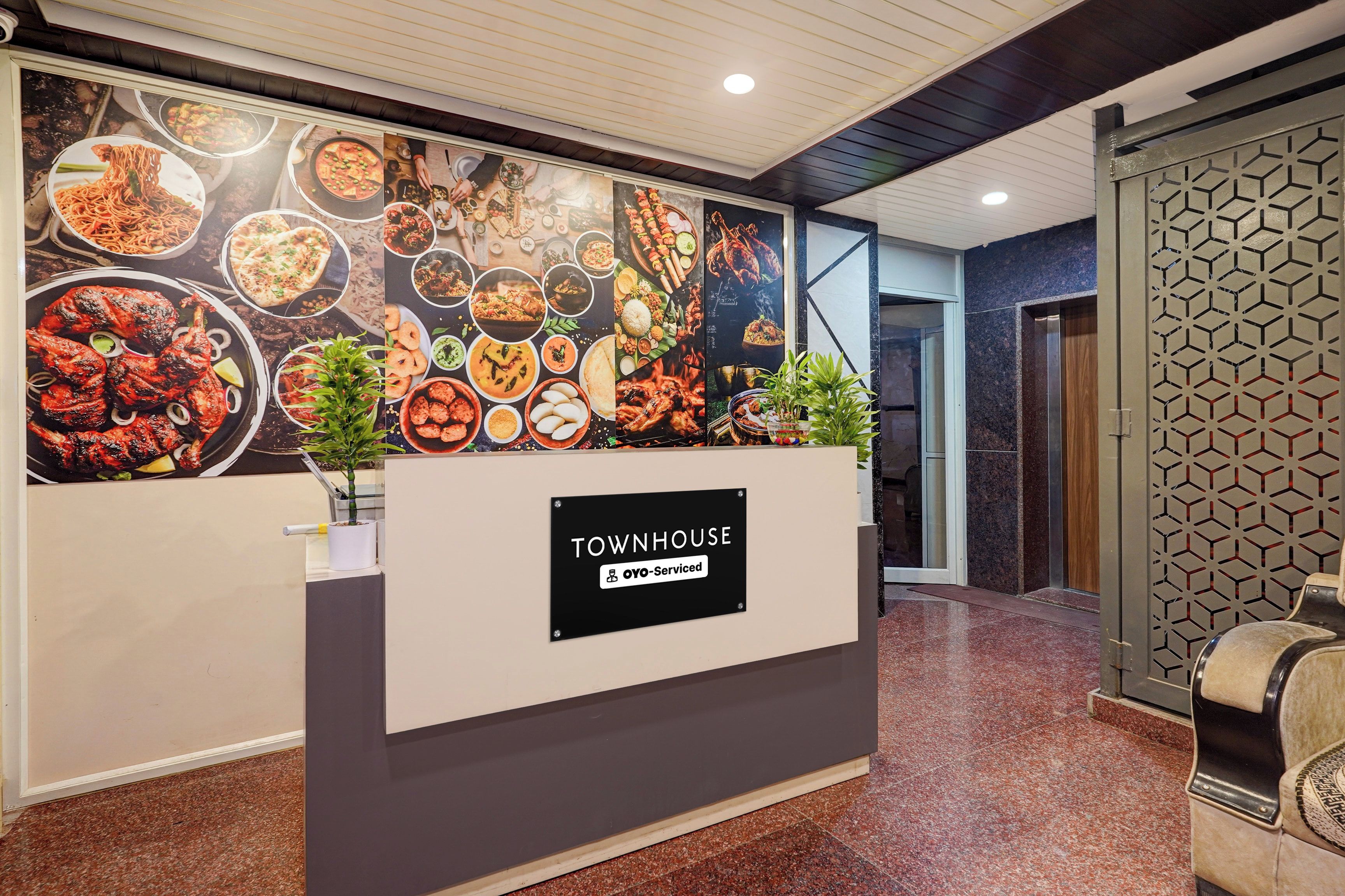 A reception desk with a sign reading 'TOWN HOUSE' and a wall of food images behind it.