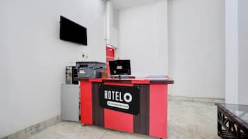 A hotel reception desk with a sign indicating it is company-serviced.