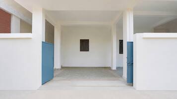 Un pasillo con una puerta a la izquierda y una ventana a la derecha.