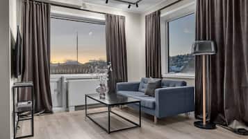 En moderne stue med sofa, sofabord og gulvlampe.