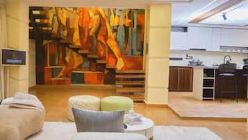 A modern interior with a spa area, a kitchen, and a staircase with a colorful abstract mural.
