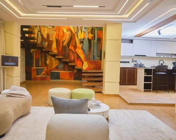 Un interior moderno con zona de spa, cocina y escalera con un mural abstracto y colorido.