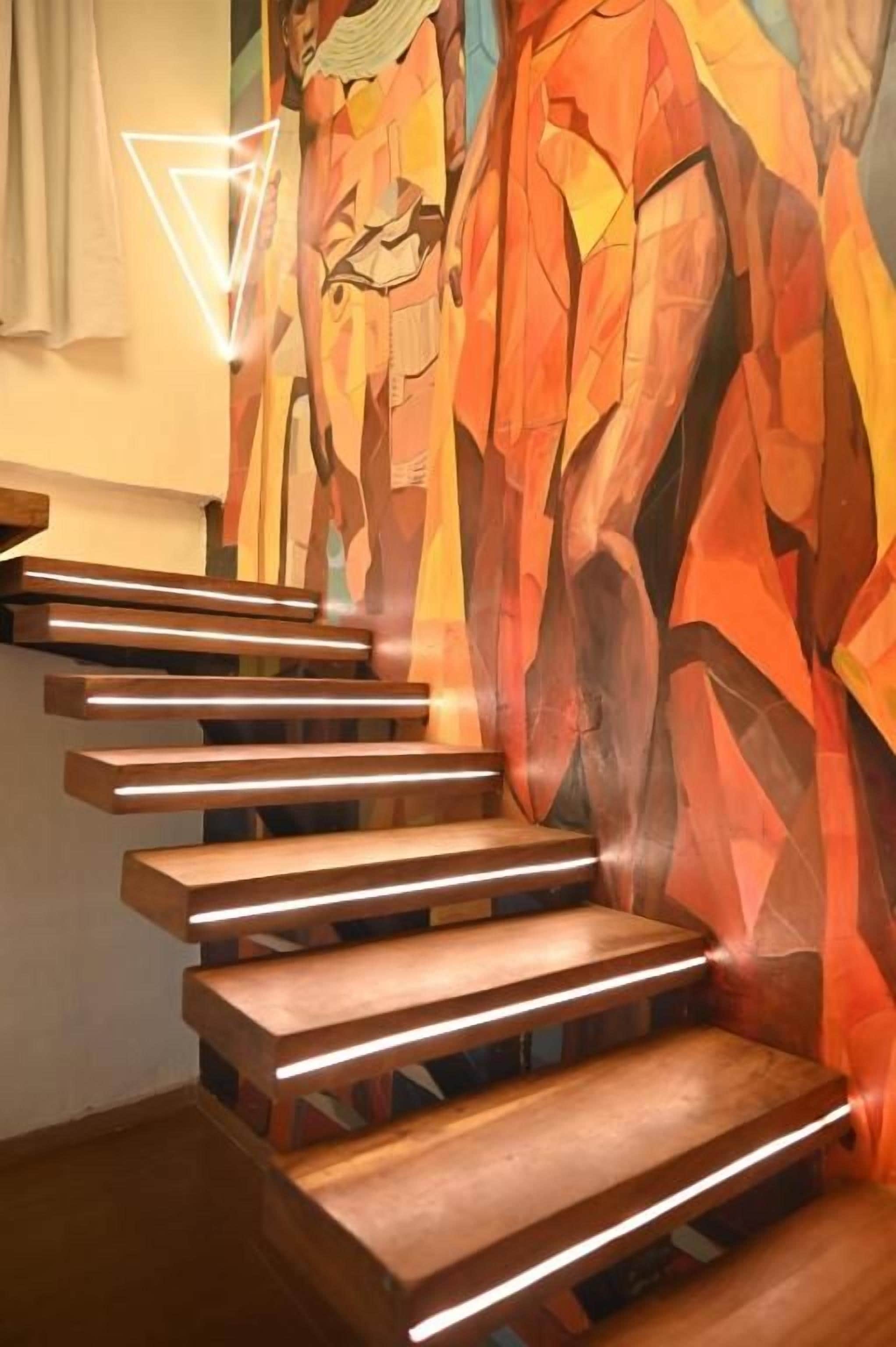 A staircase with wooden steps and a geometric mural in the background.